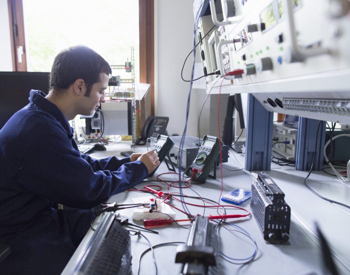 Mees elektrik remondib töökojas elektroonikaseadmeid